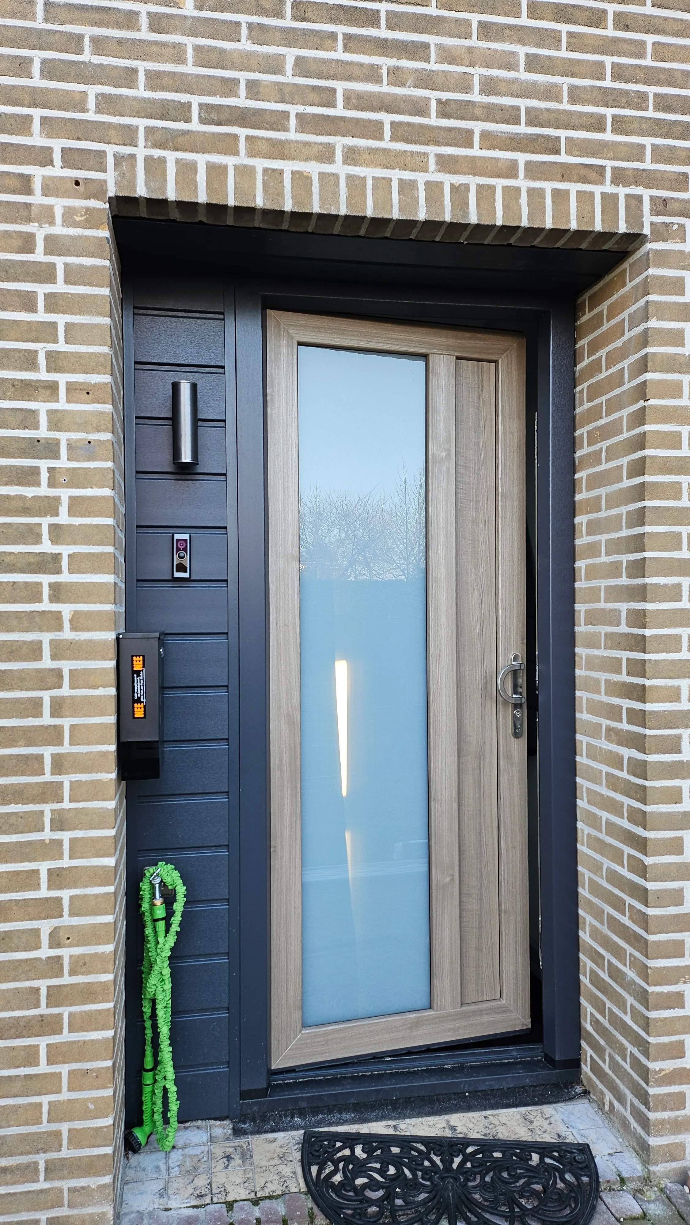 Moderne voordeur met blauwe deur en groot raam