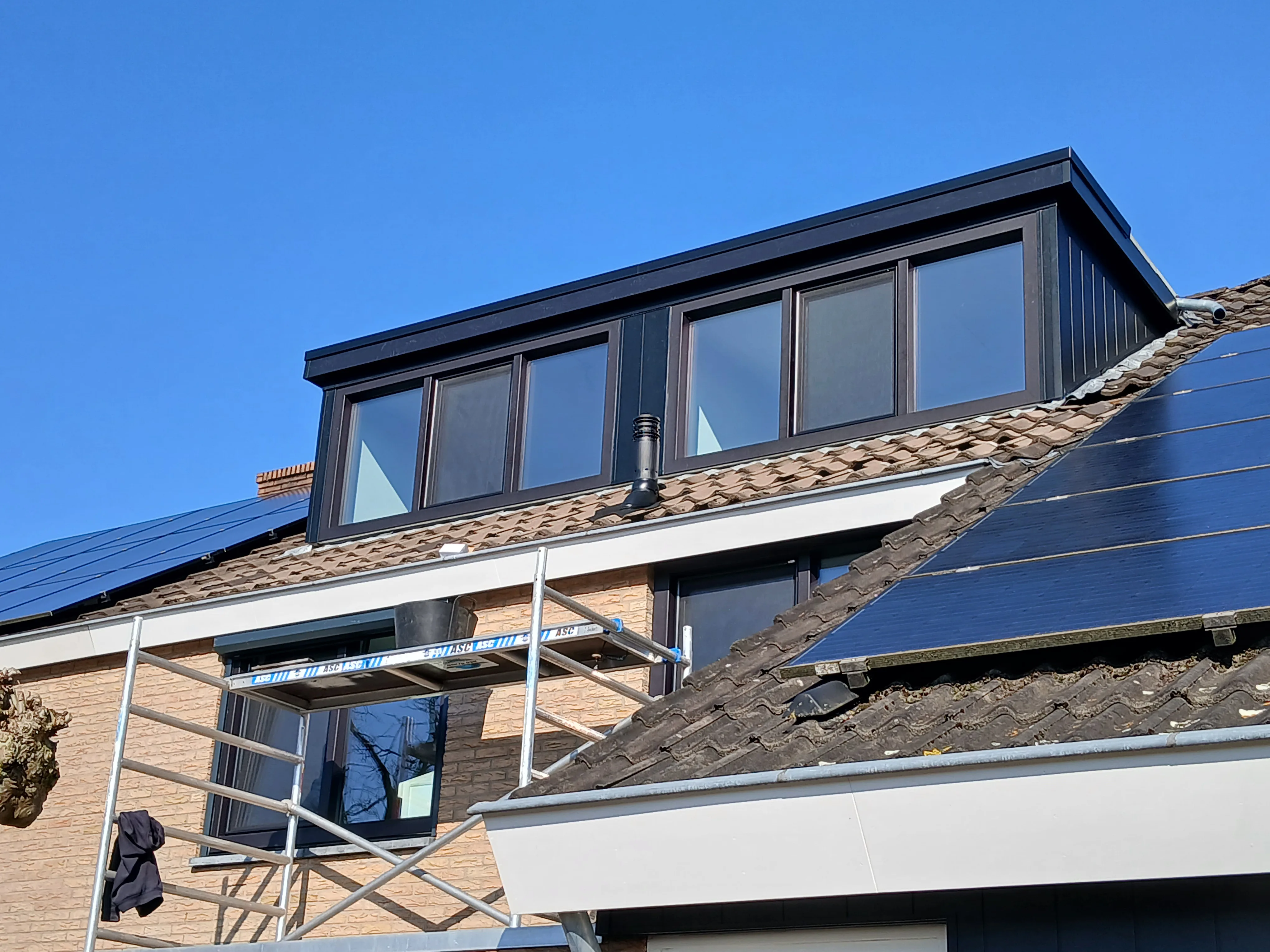 Dakraam geplaatst op een dakkapel met zonnepanelen op het dak