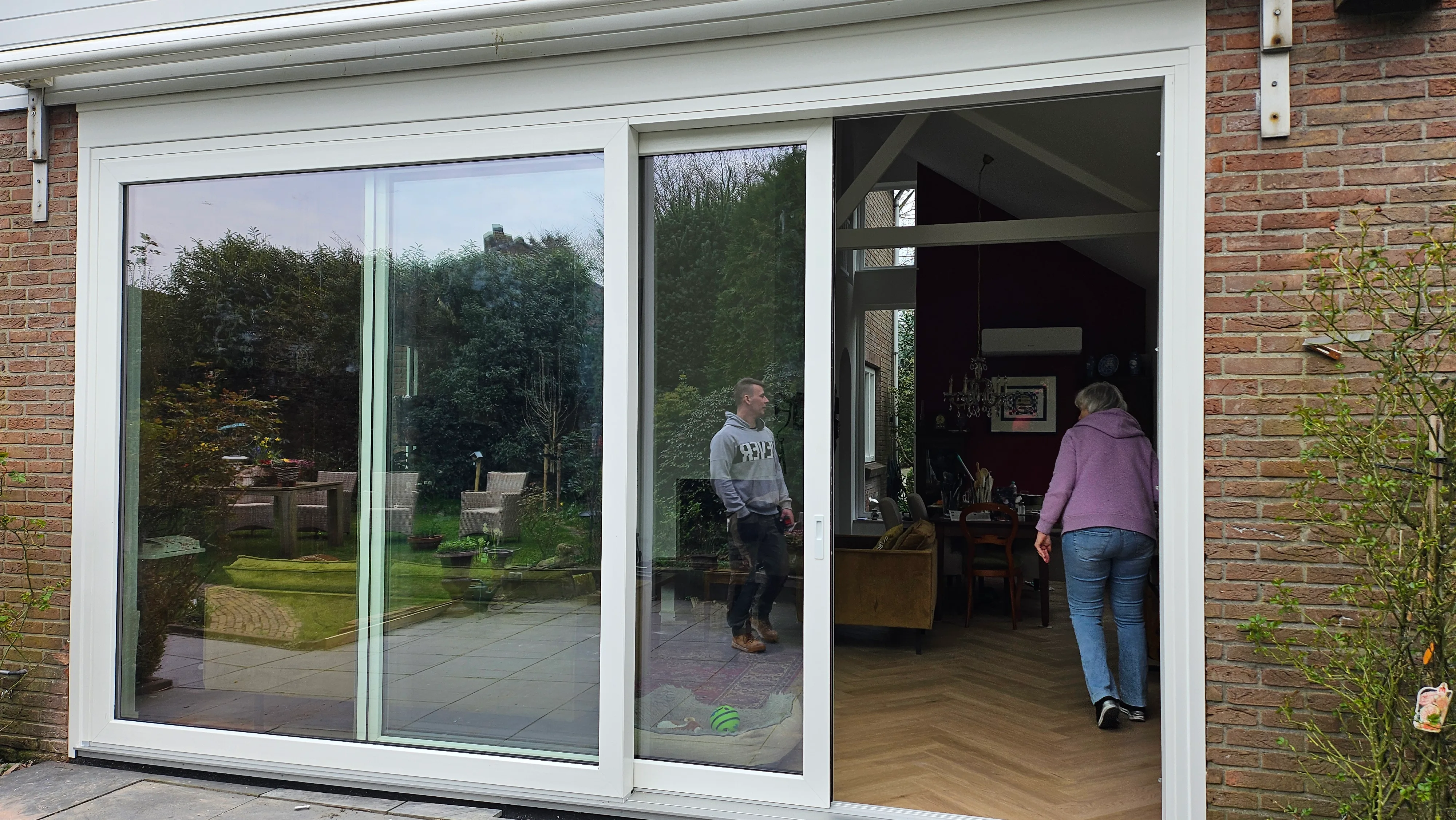 Witte kunststof schuifdeuren op bakstenen huis