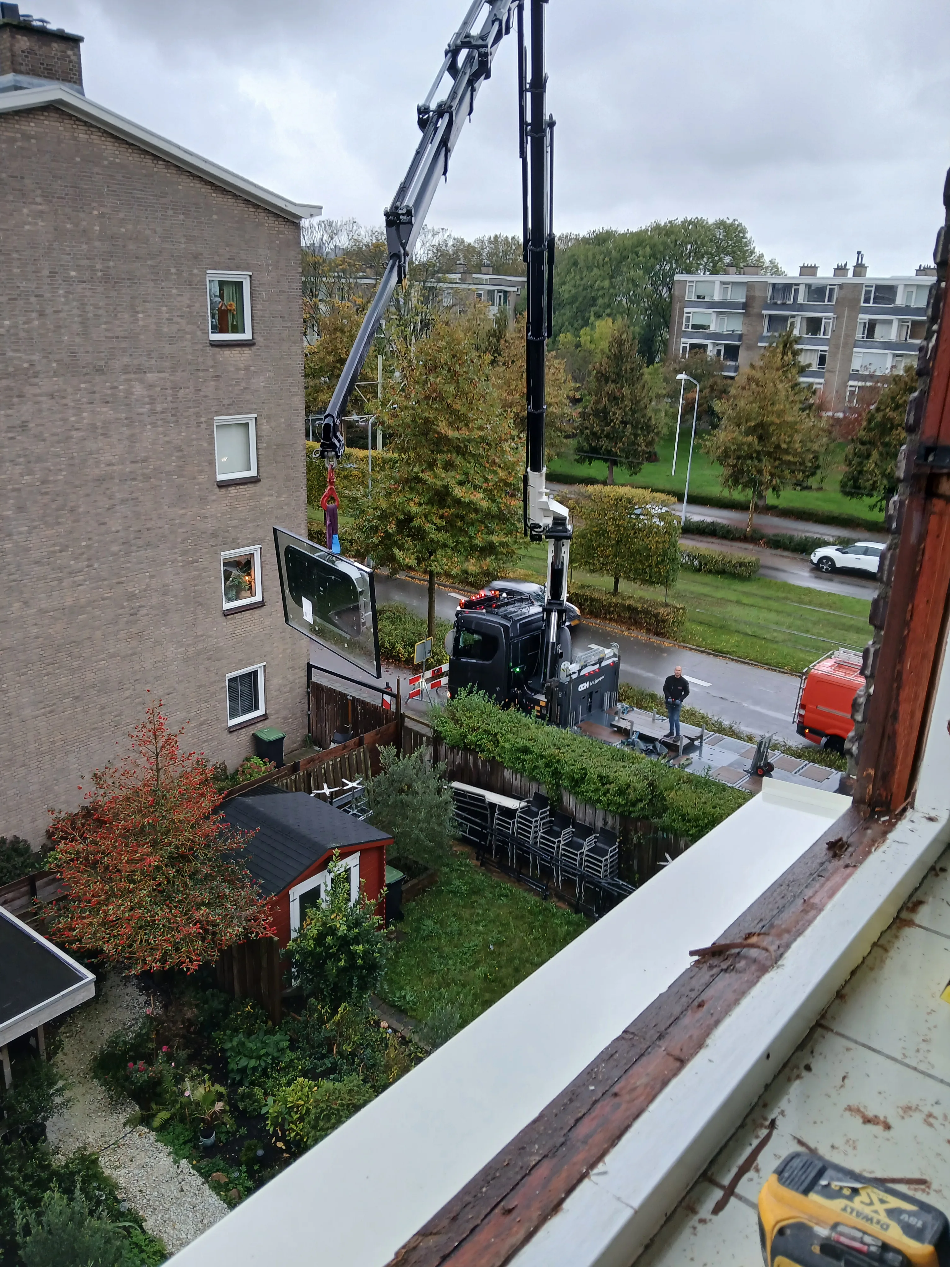 Kraanwerk op bouwplaats tussen woningen