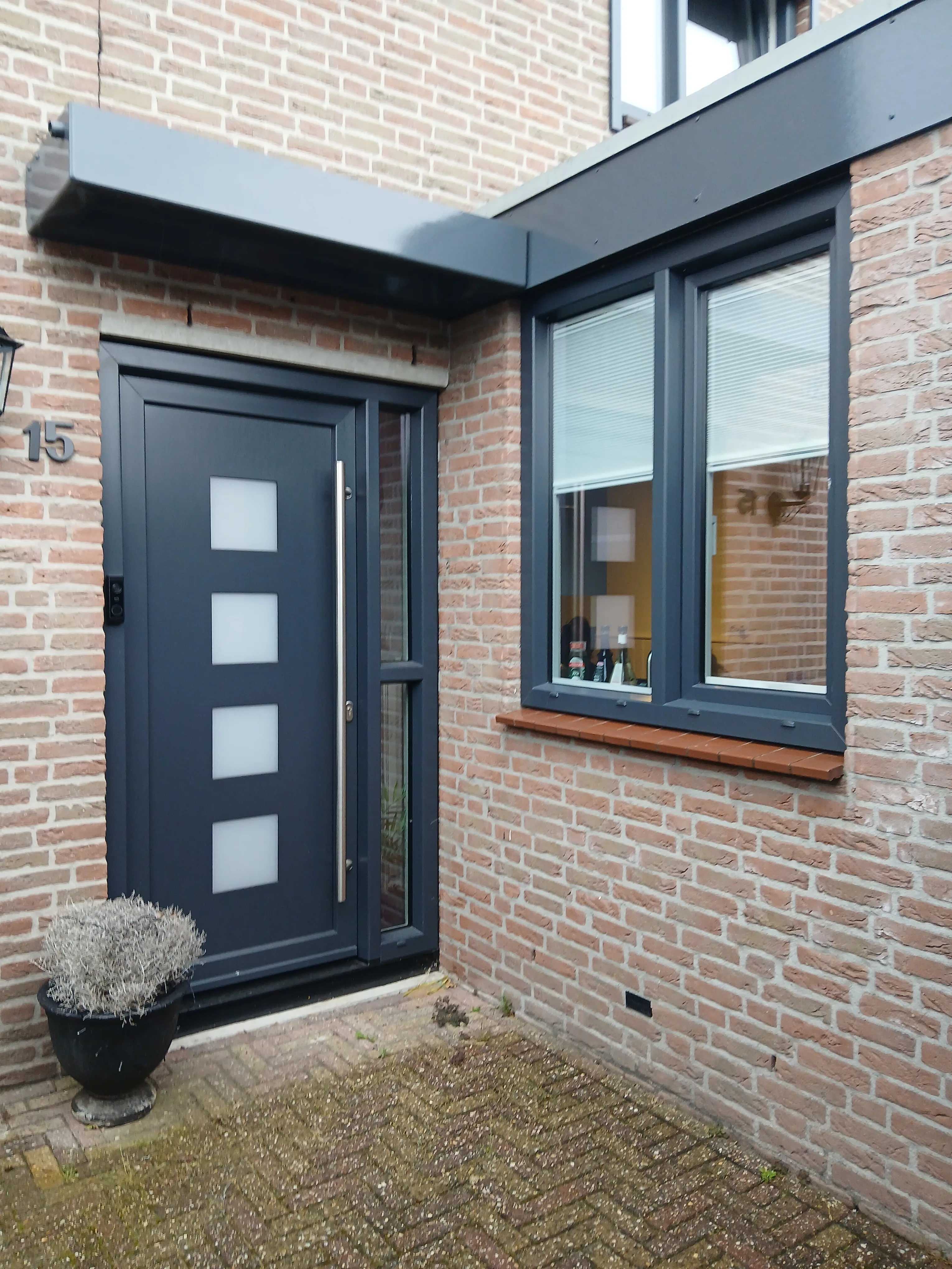 Moderne zwarte deur en raam op bakstenen gevel