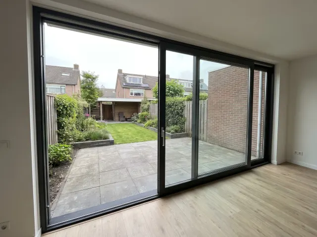 Moderne aluminium schuifpui met uitzicht op de tuin en patio