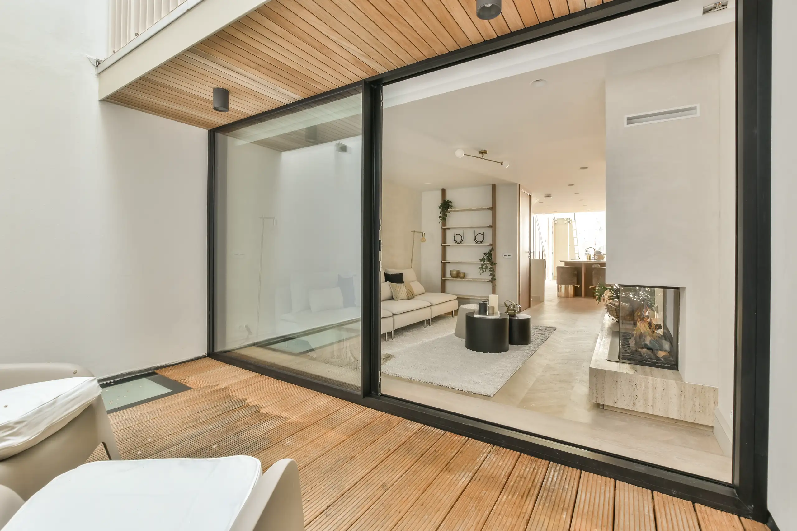 Moderne woonkamer met grote glazen schuifpui en lichte inrichting