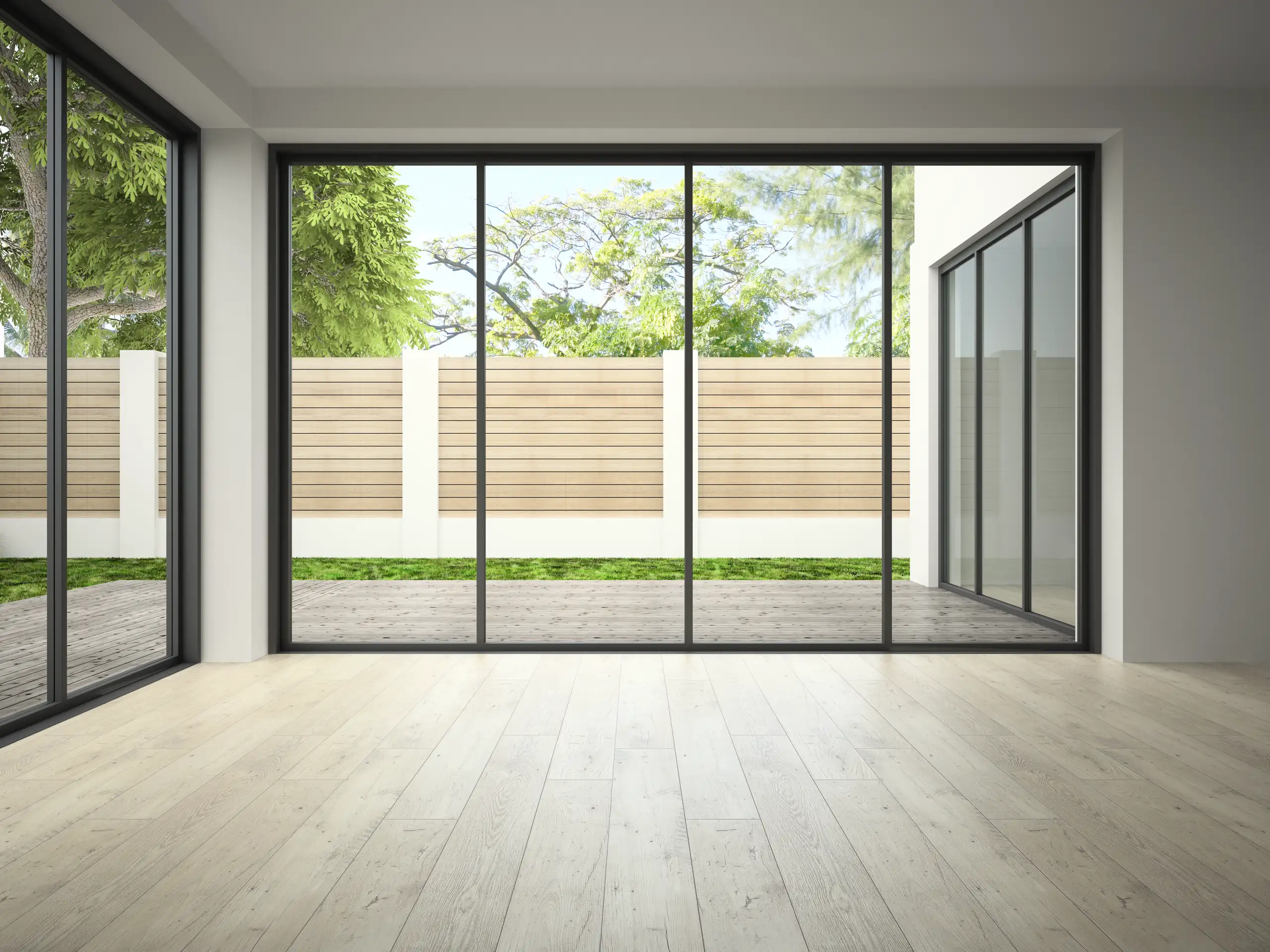 Moderne aluminium schuifpui met uitzicht op een groene tuin en houten schutting
