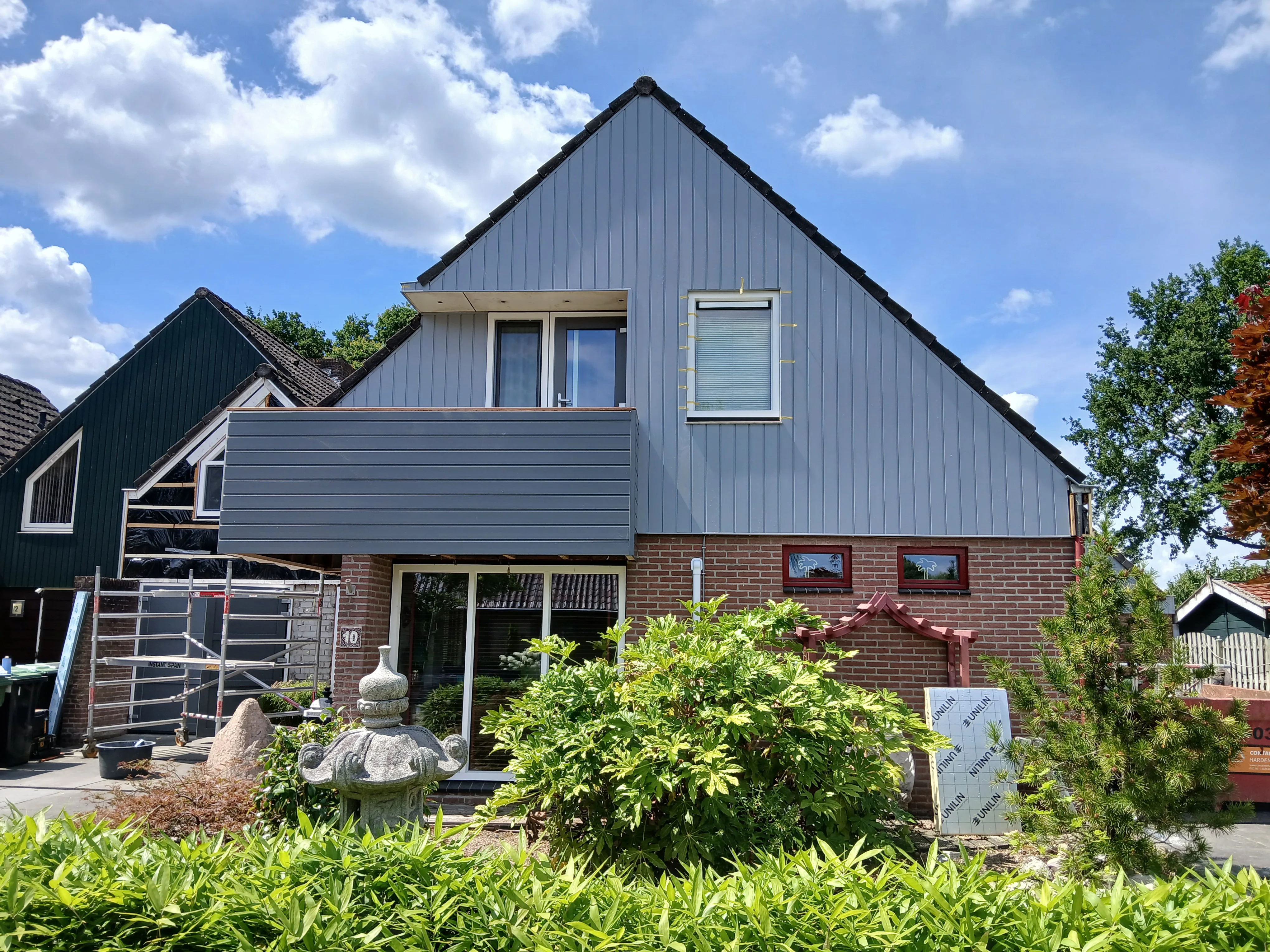 Voorzijde van een huis met kunststof gevelbekleding en grote ramen