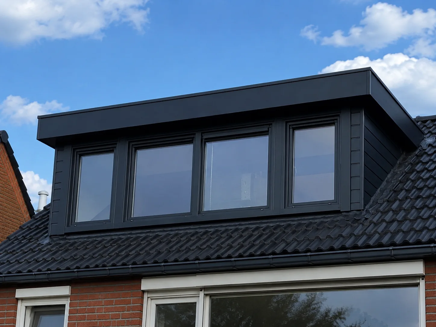 Zwart dakkapel met kunststof kozijnen en een moderne uitstraling op een woning