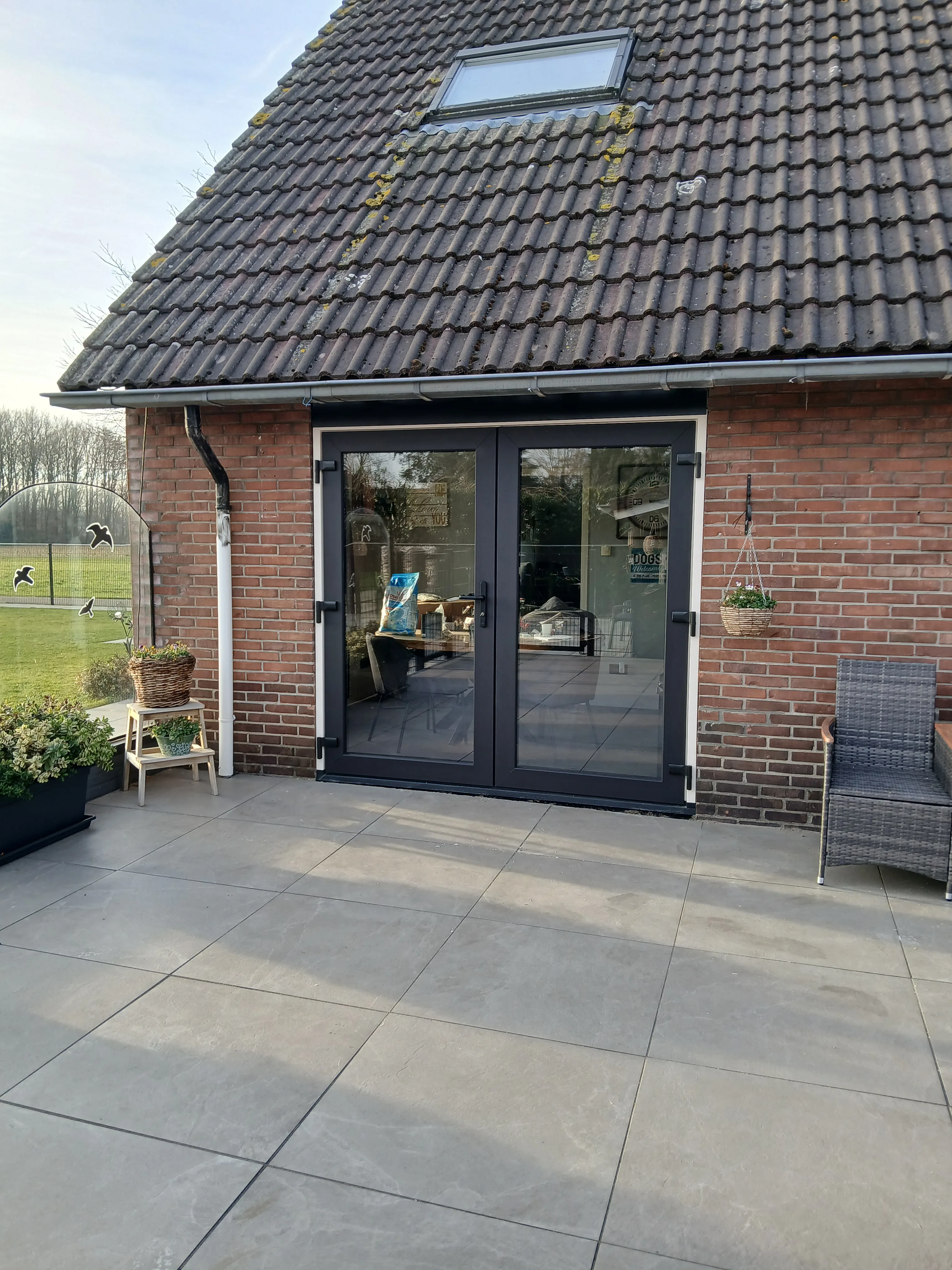 Zwart aluminium schuifpui met glazen deuren in een moderne achtertuin