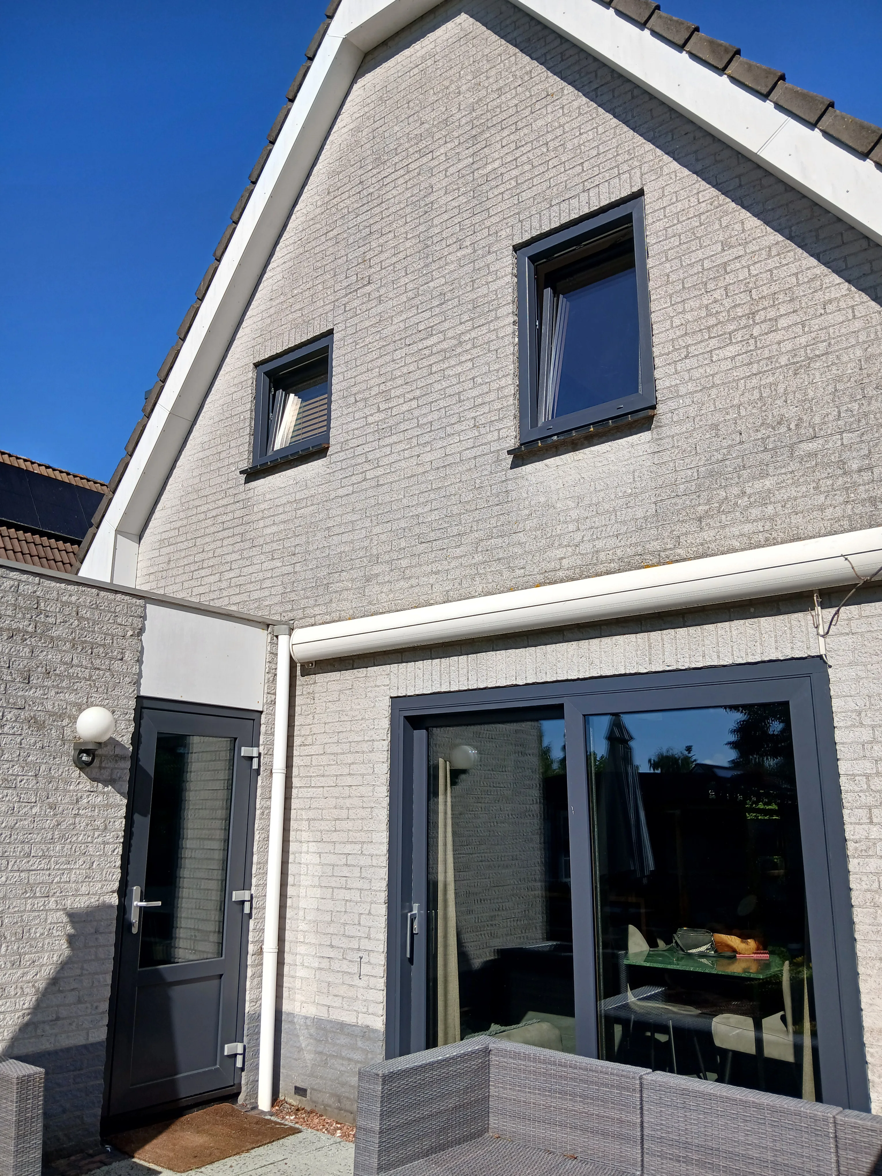 Gevel van een huis met kunststof kozijnen en een schuifpui op maat