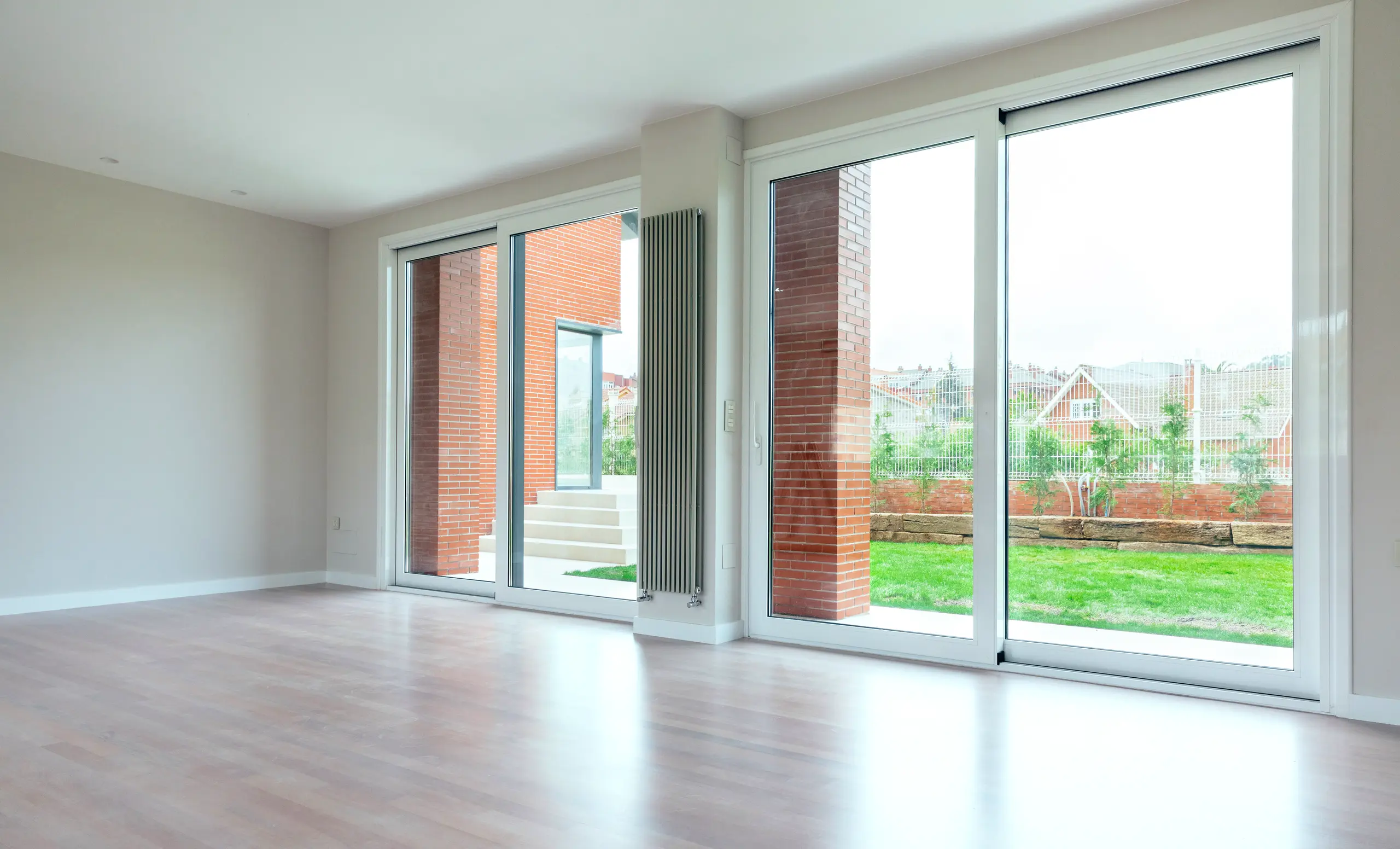 Moderne woonkamer met grote aluminium schuifpuien die naar de tuin leiden